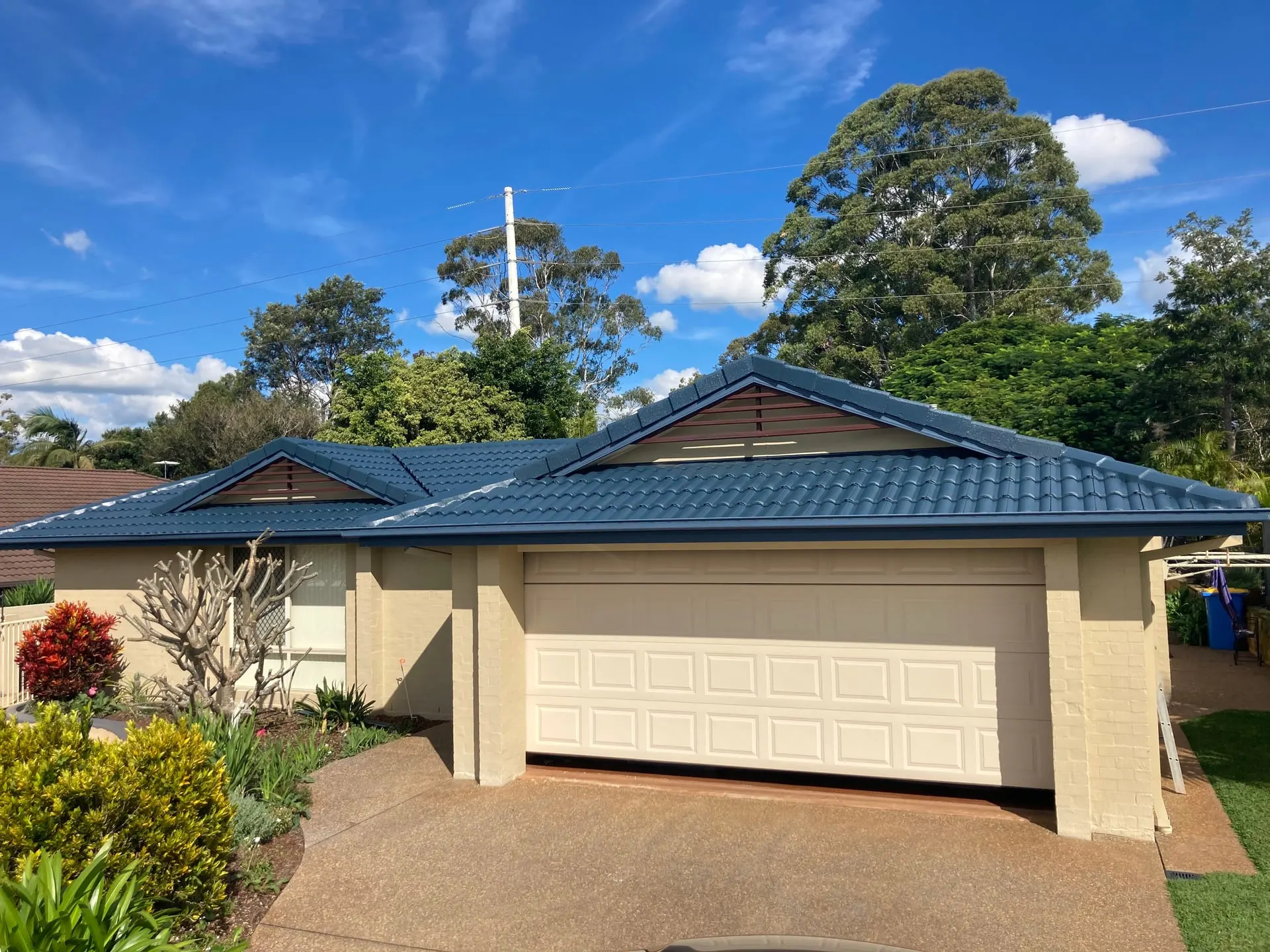 Cream home with a restored dark blue tiled roof